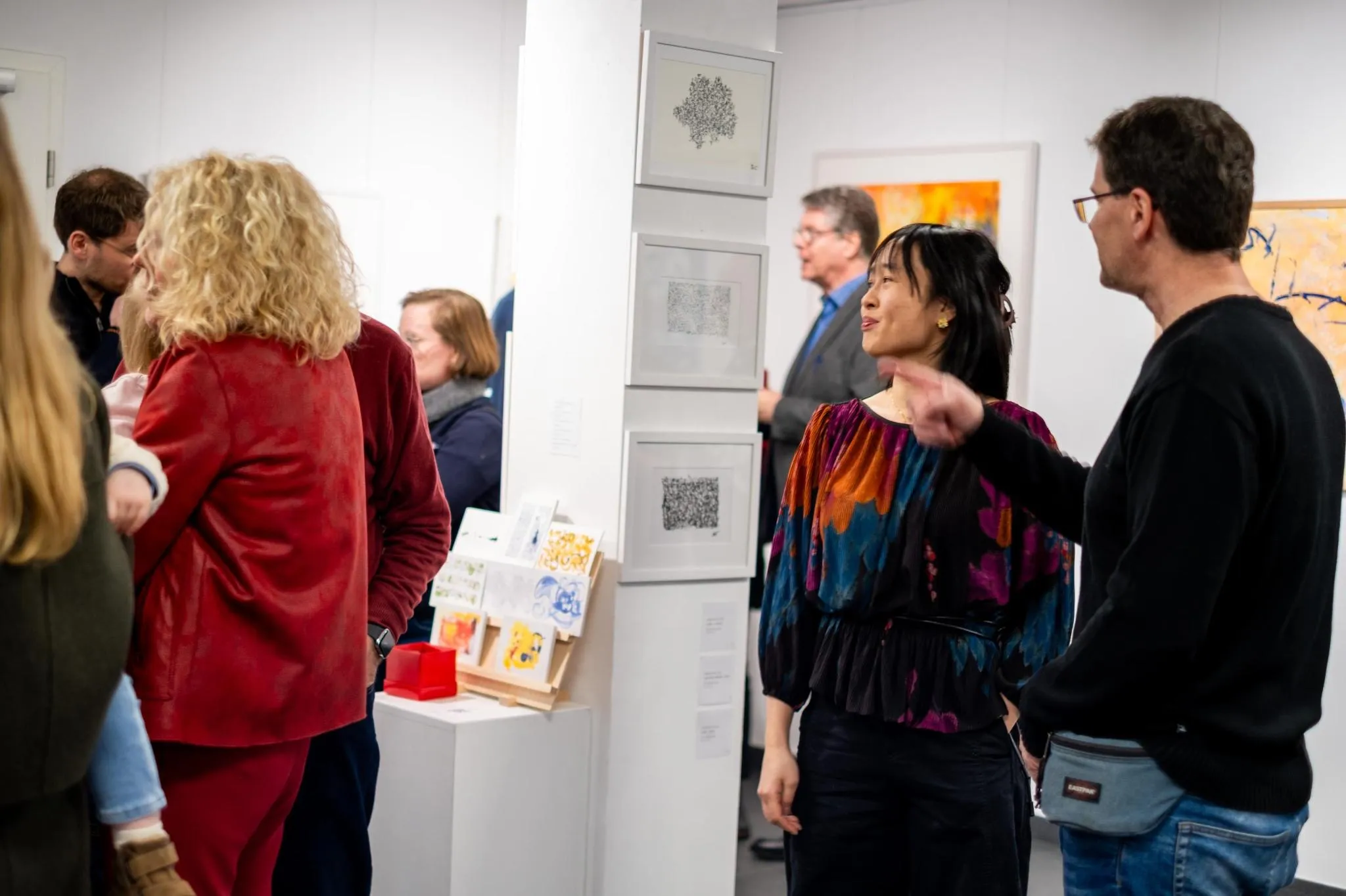 Gallery view with visitors, art cards on display, and ink drawings